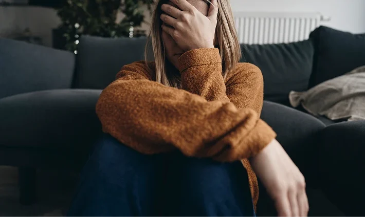 Niedergeschlagene junge Frau in Bargteheide als Sinnbild für starke innere Belastung, Überforderung und seelischen Problemen.