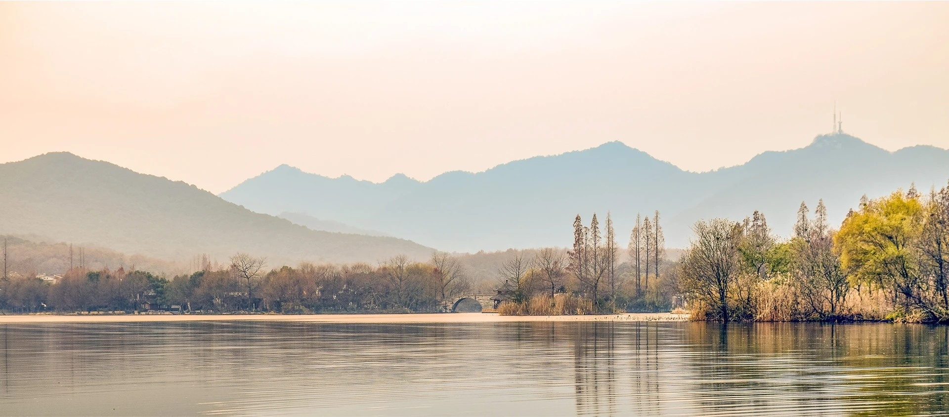 Ruhiger See in herbstlicher Natur mit Bergen im Hintergrund als Symbol für innere Ruhe und Gelassenheit.